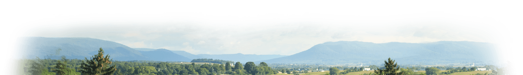 Panoramic view of rolling hills under a cloudy sky.